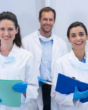 Team of dentists posing with clipboards